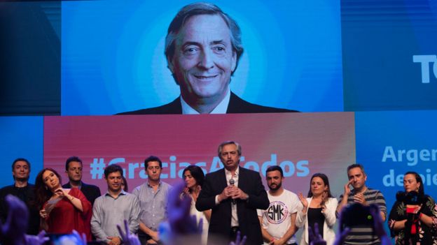 Alberto Fernández (centro) con una imagen de Néstor Kirchner detrás