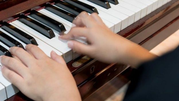 Close up child playing piano