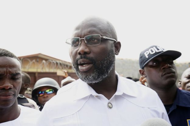 George Weah (C) leaves a polling station after casting his ballot in Monrovia, Liberia, 26 December 2017