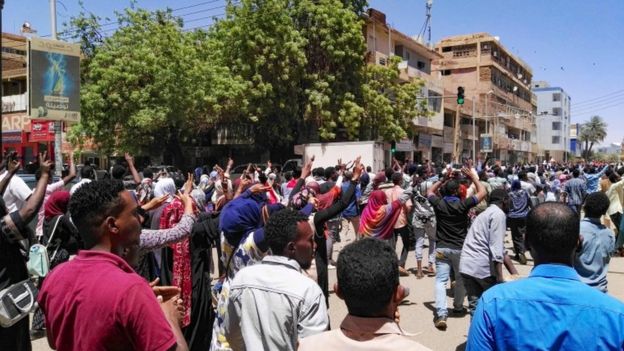 Protestors walking through the streets with their arms in the air on April 6