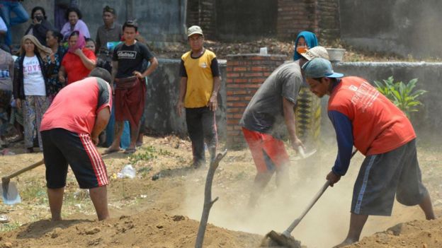 Imagem mostra homens cavando túmulo em aldeia na Indonésia