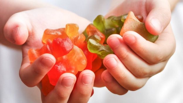 Un niño con caramelos en la mano