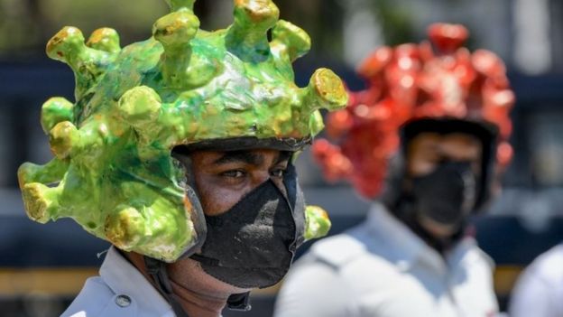 Traffic police personnel wearing coronavirus-themed helmets participate in a campaign to educate the public