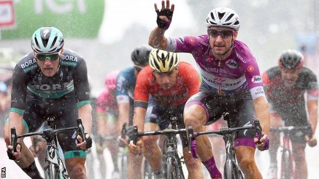 Elia Viviani celebrates victory after crossing the line on stage 17