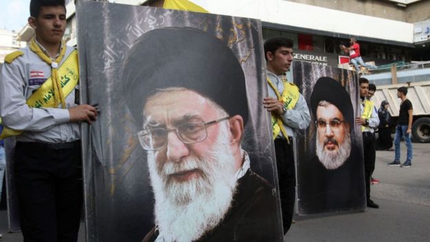 Seguidores do Hizbolah com cartazes com rostos de Alí Jamenei e Hassan Nasrallah