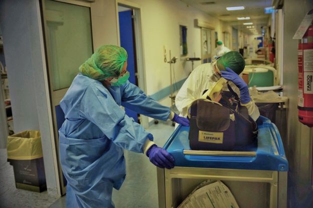 Two nurses talk in a hospital corridor