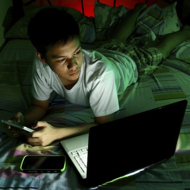 Boy using devices at night