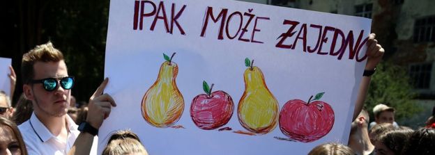 Bosnian high school students hold a placard reading 