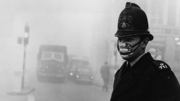 A policeman in London wearing a mask amid thick smog in 1962