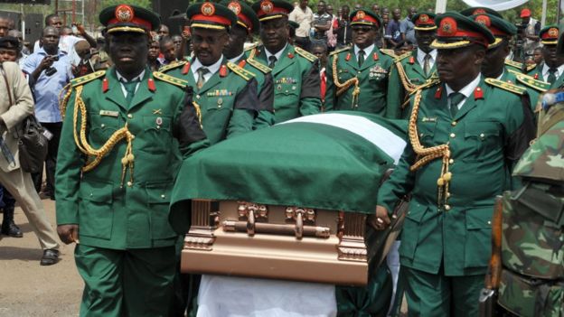 The bronze plated casket with the body of Odumegwu Ojukwu is being carried to his native Nnewi home by army pall bearers after a national inter-denominational funeral rites