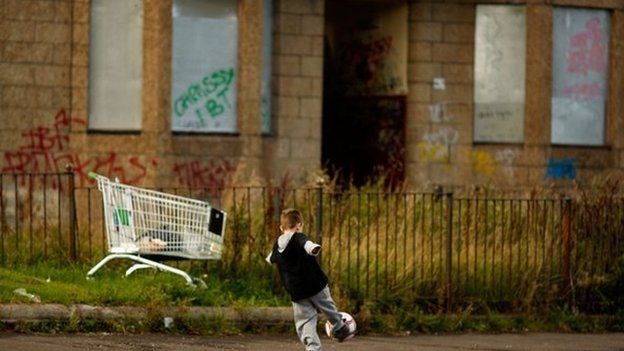 Child playing in rundown housing estate in Glasgow
