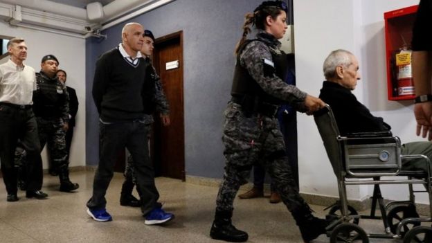Nicola Corradi (right - in a wheelchair) Armando Gómez (centre) and Horacio Corbacho (left) leave the courtroom in Mendoza