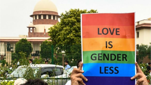 A poster saying Love is Genderless with a backdrop of the Supreme Court