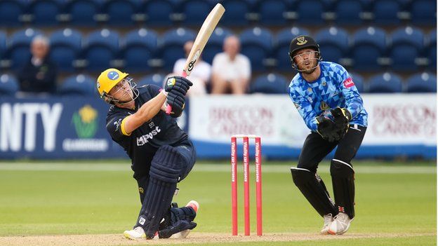 Dan Douthwaite of Glamorgan hits a six against Sussex Sharks