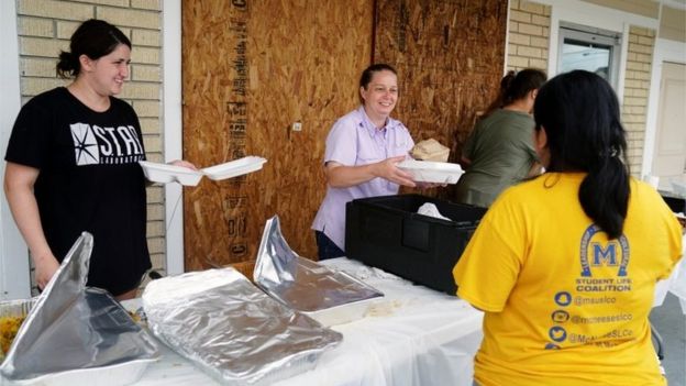 Amanda Abassi, center, serves free hot food to community members with her daughter and extended family in front of her restaurant Royal Tandoor after Hurricane Laura passed through the area in Lake Charles, Louisiana, U.S. August 28, 2020