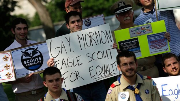 Boy holds sign reading'Gay, Mormon, Eagle Scout for Equality'