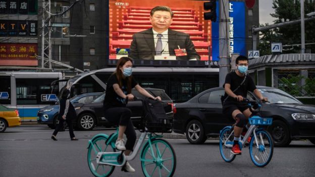 Chinese president Xi Jinping is seen on a large screen in the streets of Beijing