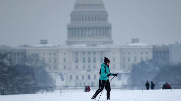 Un esquiador de campo traviesa pasa el Capitolio de los EE. UU. Durante una tormenta de invierno el 13 de enero de 2019 en Washington