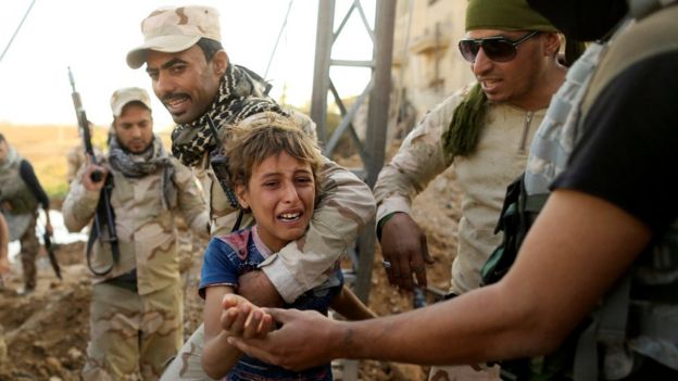 Iraqi soldiers help a child flee the front line in Mosul. 4 Nov 2016