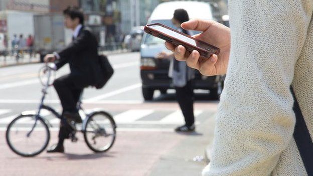 Man using mobile phone on street in Tokyo, Japan