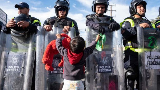 Küçük bir çocuk Meksika polisinin kurduğu barikatın önünde