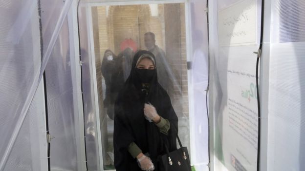 An Iranian woman walks through a disinfectant tunnel at Tehran's Abdol Azim shrine on 25 May 2020