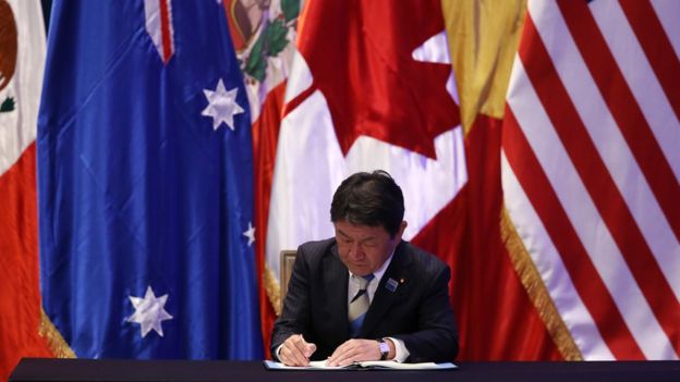 Image captionEl ministro de revitalización económica de Japón, Toshimitsu Motegi, firmó el CPTPP en marzo de 2018.