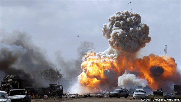 Vehicles belonging to forces loyal to Libyan leader Colonel Gaddafi explode after an air strike by coalition forces, along a road between Benghazi and Ajdabiyah, 20 March 2011