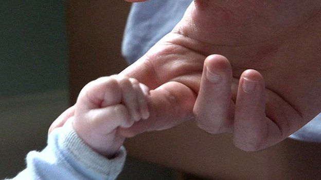 Baby holding adult's hand