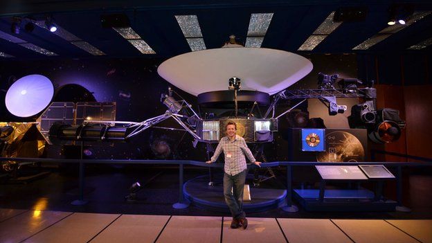Chris Riley next to the Voyager model at JPL
