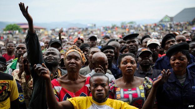 Residents of Goma react as they listen to M23 rebel group spokesman at a stadium in Goma, 21 November 2012