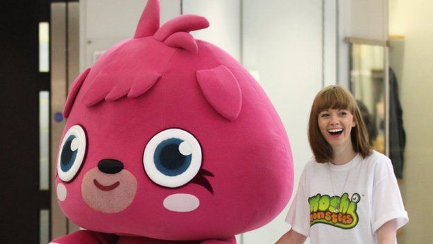 A sales assistant walks the Moshi Monster 'Poppet' to a pop-up shop selling merchandise from the children's online game 'Moshi Monsters'