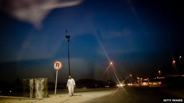 A man walking on the street at night in Misrata, Libya