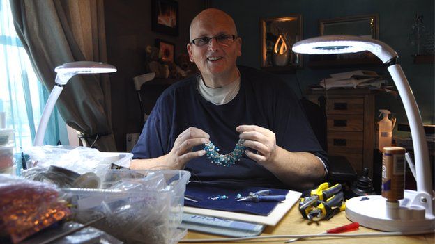 Paul Mason holds a handmade necklace