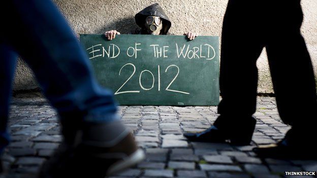 Man in gasmask holding "End of the world 2012" sign