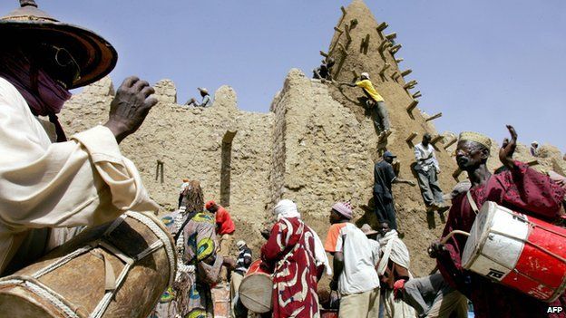 Archive shot from 2006 of residents of Timbuktu encouraging workers restoring the City of 333 Saints' Great Mosque