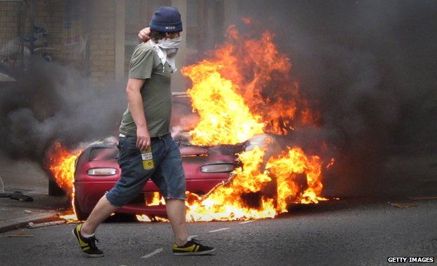 Masked man near burning car, 2011