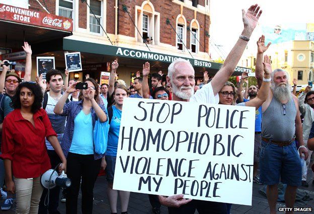 protester holding placard which reads: Stop police homophobic violence against my people