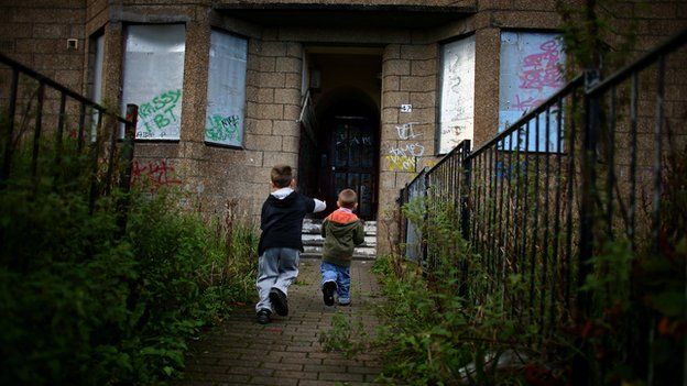 Children playing outside a derelict house
