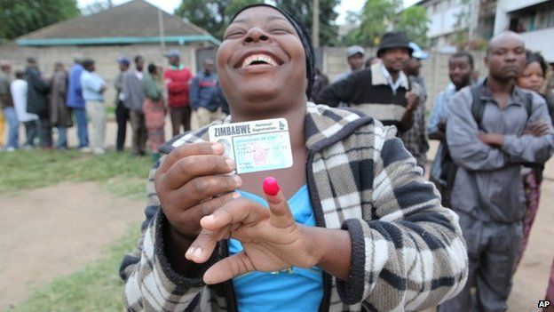 A woman shows her ink stained index finger after casting her vote during a referendum in Harare, Zimbabwe, Saturday 16 March 2013