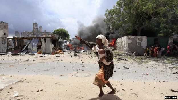 A Somali woman runs to safety near the scene of a blast