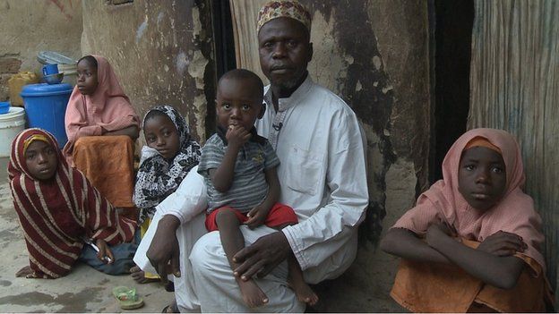 Usman Al Hassan and his children, including on his lap Abubarkar who contracted polio in 2013, on their home in the outskirts of Nigeria's capital, Abuja