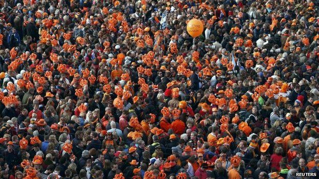 An orange balloon is seen above the crowd gathered for Queen Beatrix's abdication ceremony in Amsterdam.