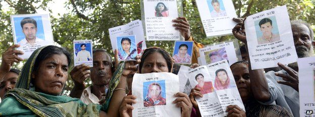 Relatives hold up portraits of those missing from the collapse of a garment factory in Savar, Bangladesh