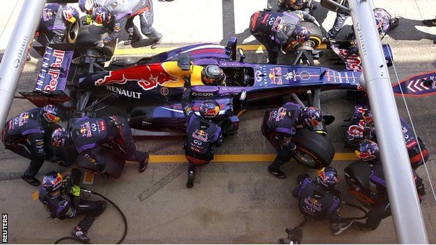 Red Bull staff work on Sebastian Vettel's car at a pit stop in the Spanish Grand Prix