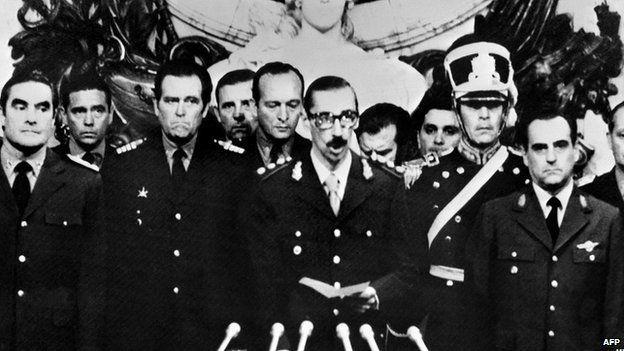 General Orlando Ramon Agosti (R) and Admiral Emilio Massera (L) stand as Lieutenant General Jorge Rafael Videla (C), President of Argentina, takes an oath as 38th president of the Argentine Republic, 29 March 1976, in Buenos Aires.