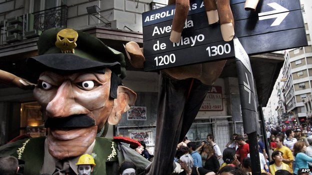 Demonstrators hold a figure representing Jorge Videla grabbing a street sign in Buenos Aires, 24 March 2006