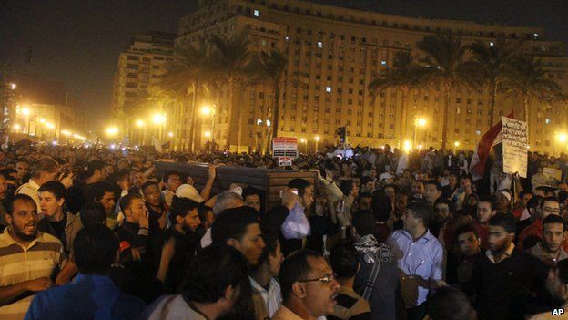 Mourners carry a coffin from Cairo's Zeinhom mortuary to Tahrir square