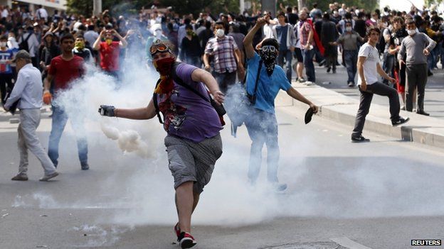 A protester throws a gas canister back at riot police during a demonstration in Ankara 3 June 2013