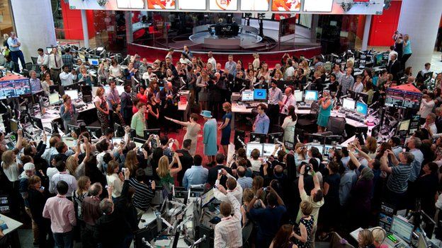 Queen surrounded by staff in the main newsroom